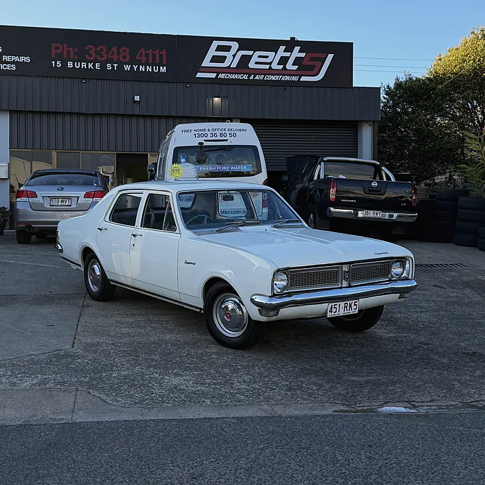 A white classic Holden Kingswood out the front of the workshop