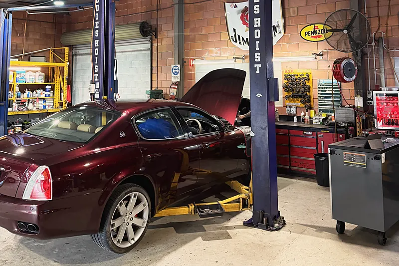 A red Maserati Quattroporte up on the hoist for a look underneath