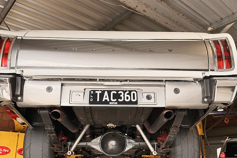 Rear axle, springs and shocks of a classic ute up on the hoist